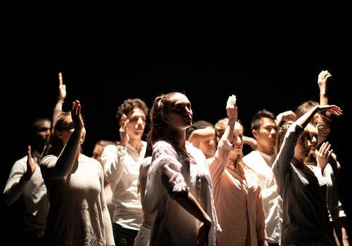 Pose de danseurs sur scène, les bras sont en mouvement