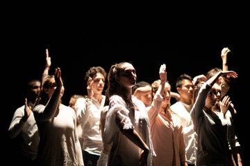 Groupe d'étudiants-danseurs sur scène, les bras en mouvement